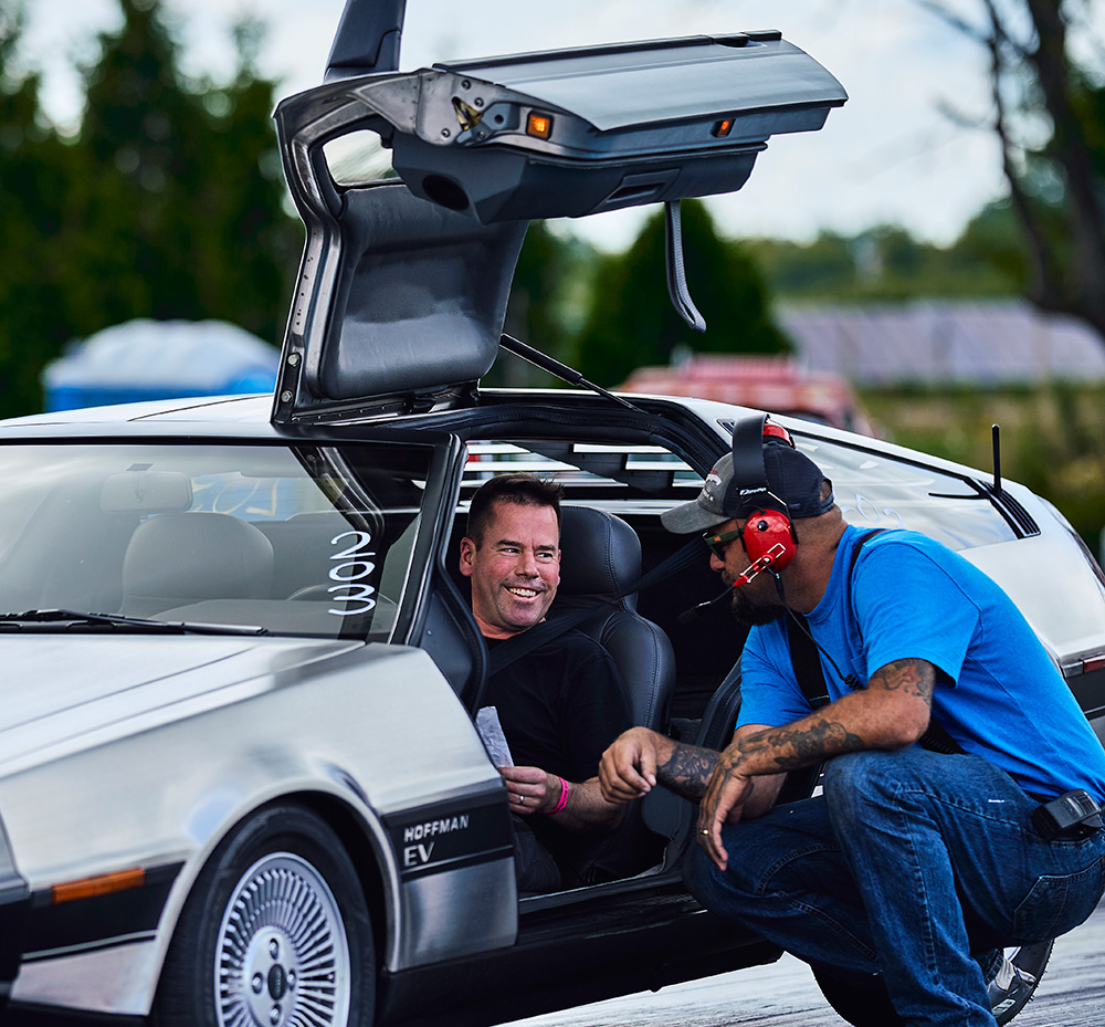 Hoffman EV founder and owner Geoff Hoffman sitting in a Delorean